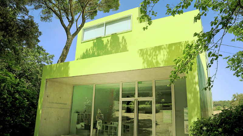 Façade d'un établissement centre d'activités aux couleurs vives jaune et vert. Espace de l'Art Concret - Baby Visite
