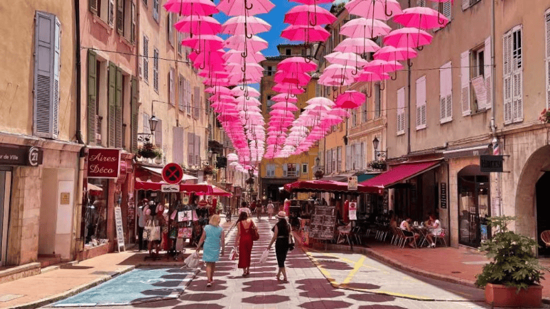 allée animée , avec parapluies colorés. ExpoRose — Festival de la rose en famille à Grasse