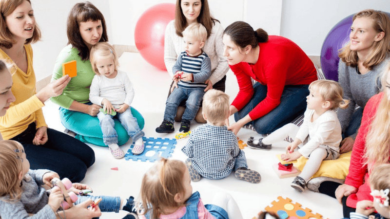 Animatrice entourée d'enfants en bas âge lors d'un atelier d'éveil. KidooLand - Discovery Den, éveil bilingue