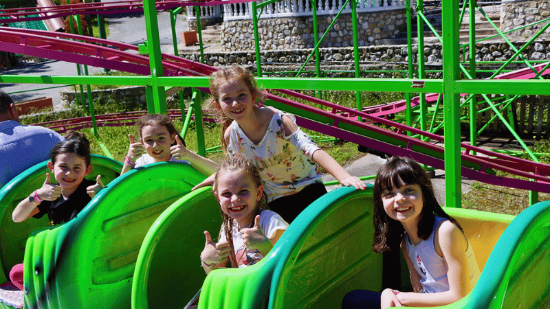 enfants tout sourire installé dans un manège
