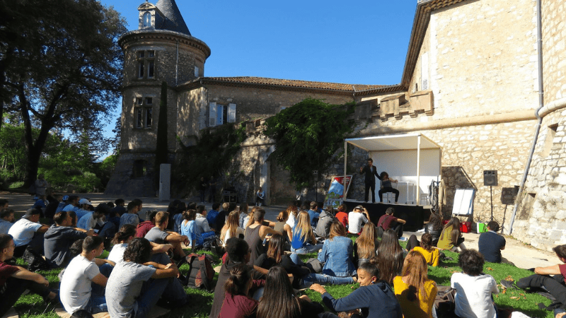 lecture plein air devant un public de jeune enfant . Le_Festival_du_Livre_Mouans-Sartoux.
