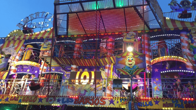 grande roue et manèges colorés illuminés la nuit dans une fête foraine