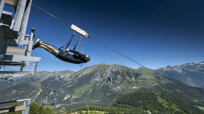 personne en tyrolienne au-dessus d’un paysage montagneux